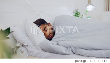 Man, bed and sleeping in home for rest, wellness or recharge for body, mind and spirit for peace. Young, gen z guy and apartment bedroom for sleep, relax and health for dream, quiet or lying in house 106950718