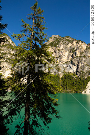 Alpine lake Braies amidst rocky peaks of Dolomite mountains, Italy 106952809