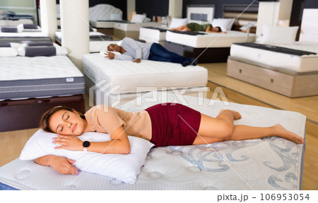 Young woman fell asleep on new mattress in a furniture store Young woman fell asleep on new mattress in a furniture store 106953054