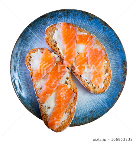 On table there is plate with homemade light snack - toast, crispy salmon sandwiches 106953238