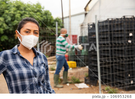 Portrait of woman farmer wearing protective mask in the backyard of house Portrait of woman farmer wearing protective mask in the backyard of house 106953268