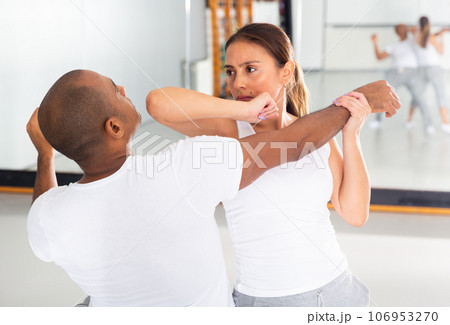 Woman and man at self protection workout, training attack movements Woman and man at self protection workout, training attack movements 106953270