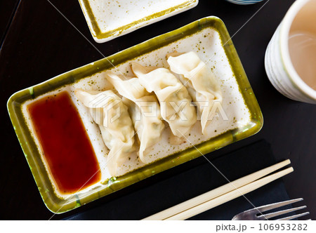 Steamed Yaki Gyoza served in a plate with sauce Steamed Yaki Gyoza served in a plate with sauce 106953282