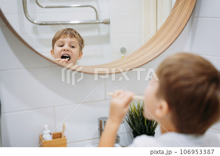 cute 5 years old boy brushing teeth with bamboo tooth brush in bathroom. Image with selective focus 106953387