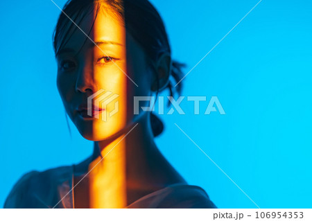 カラーライティングを使った女性ポートレートの写真素材 [106954353