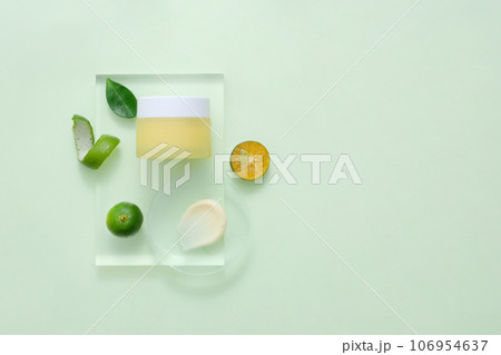 Mockup packaging, cosmetic jar unbranded for design is displayed on transparent podium with slices of kumquat. Concept for advertising natural cosmetic 106954637