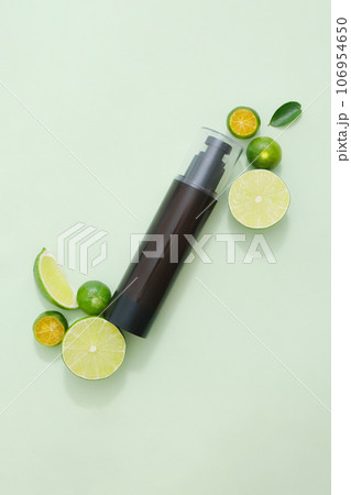 Mockup scene for advertising product with natural ingredient rich in vitamin C - kumquat and lime. An amber bottle unbranded for design packaging. Top view, minimalist concept 106954650