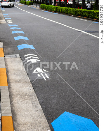 車道の左端に設置された自転車ナビマーク（白色）と自転車ナビライン（青色） 106954736