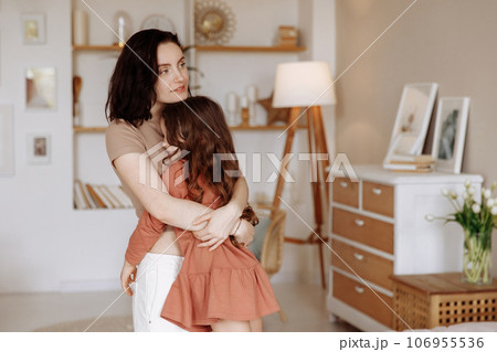 Cute little girl hugging happy young mother 106955536