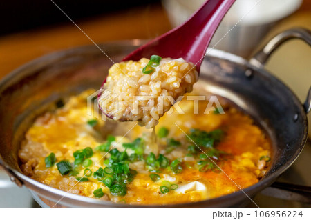 ピリ辛モツ鍋の雑炊をスプーンでリフト 106956224