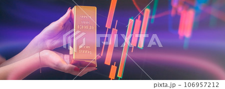 Girl holding gold bar , Business graph background . Buying gold investment 106957212
