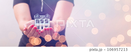 The concept of buying and selling real estate. A man with a model of a house on the background of the forex chart. 106957213