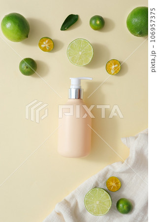 Flat lay of blank label pump bottle decorated with kumquat and lime on white towel. Lime and Kumquat help keep kidney stones at bay. Organic fruit concept Flat lay of blank label pump bottle decorated with kumquat and lime on white towel. Lime and Kumquat help keep kidney stones at bay. Organic fruit concept 106957375
