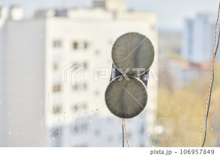 A window cleaner robot washes glass against the backdrop of multi-storey buildings. 106957849