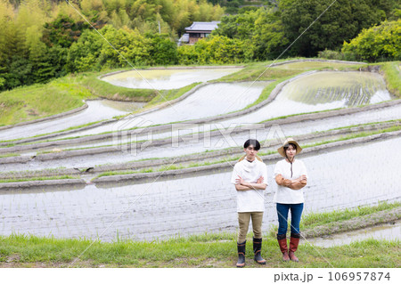 田んぼと若い夫婦 106957874