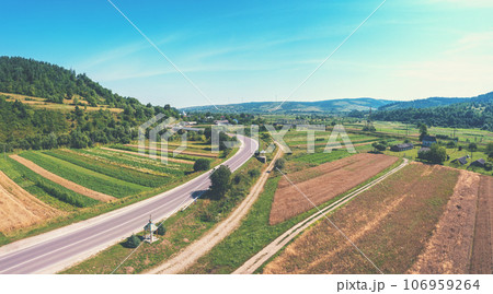 Aerial view of the countryside, highway, and cultivated fields on the hills 106959264