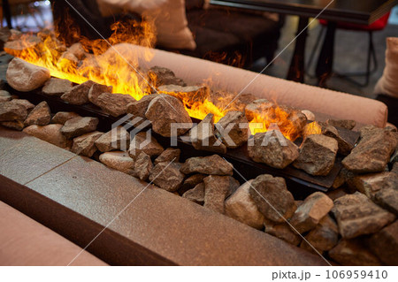 Electric log fireplace. Restaurant showcase decorated with artificial heater. Exterior design. 106959410