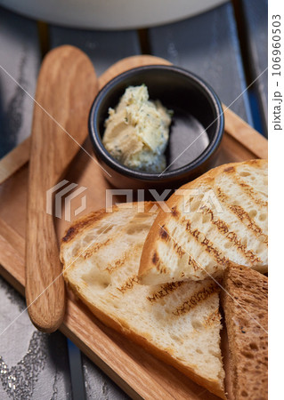 A piece of rye bread with a bunch of thyme on a wooden old stand. Farmer's early Breakfast. 106960503
