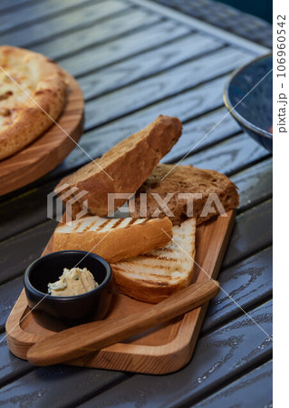 A piece of rye bread with a bunch of thyme on a wooden old stand. Farmer's early Breakfast. 106960542