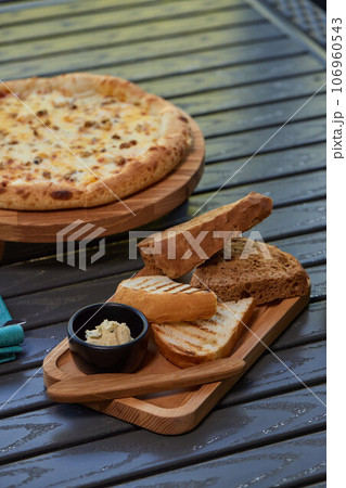 A piece of rye bread with a bunch of thyme on a wooden old stand. Farmer's early Breakfast. A piece of rye bread with a bunch of thyme on a wooden old stand. Farmer's early Breakfast. 106960543