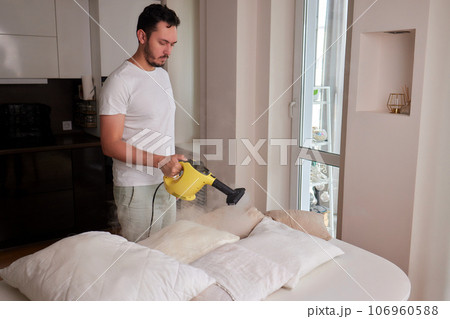 Using dry steam cleaner to sanitize pillow. 106960588