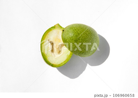 The green outer shells of the unripe walnuts are cut in half, green walnuts 106960658
