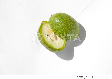 The green outer shells of the unripe walnuts are cut in half, green walnuts The green outer shells of the unripe walnuts are cut in half, green walnuts 106960659