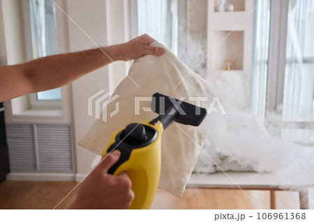 Using dry steam cleaner to sanitize pillow. Using dry steam cleaner to sanitize pillow. 106961368