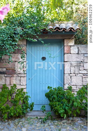 Wooden blue door of nostalgic house in Cunda Island, Ali Bey Island, Ayvalik, Balikesir, Turkey september 11 2020 106962259