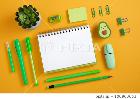 Empty page with green stationery on yellow backdrop. Avocado-shaped eraser 106963653