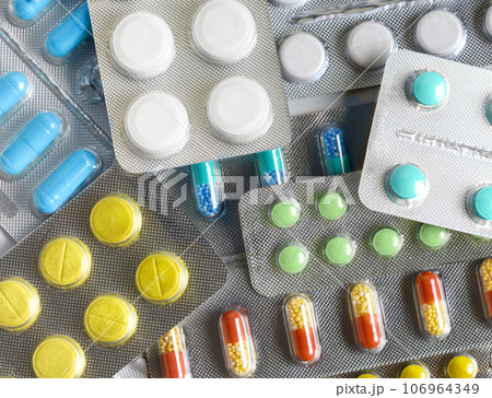 A lot of colorful medicine pills and capsules in blister packs 106964349