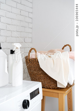 Laundry room with washing machine and basket with laundry 106965444