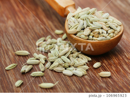 Fennel seeds in a wooden spoon 106965923