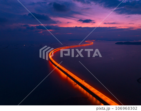 Aerial view of highway light of Penang Second Bridge with dramatic twilight sunset colorful sky background Aerial view of highway light of Penang Second Bridge with dramatic twilight sunset colorful sky background 106968302