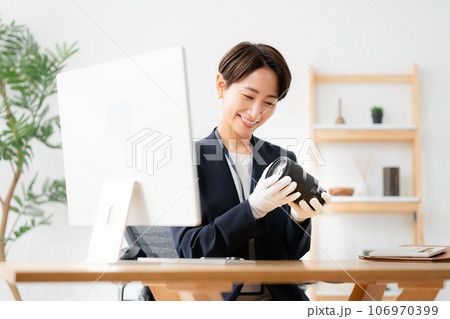 カメラレンズを査定する店員 106970399