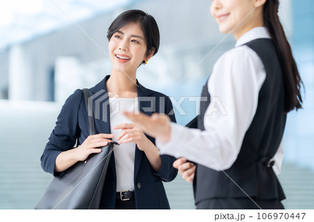 オフィスのロビーで若いビジネスウーマンを案内する受付嬢 オフィスのロビーで若いビジネスウーマンを案内する受付嬢 106970447