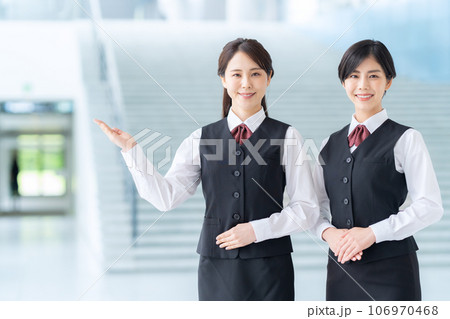 ロビーで案内する若い受付嬢 106970468
