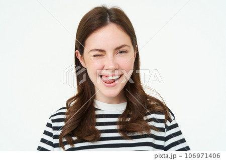 Portrait of happy, beautiful young woman, smiles and winks at you, stands over white background Portrait of happy, beautiful young woman, smiles and winks at you, stands over white background 106971406