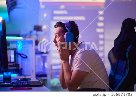 Player looking at his computer screen, contemplating his next move in an online video game. 106971702