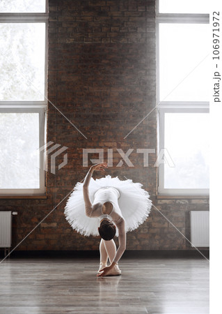 Classical ballet dancer doing roll down at end of her performance Classical ballet dancer doing roll down at end of her performance 106971972