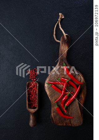 Red chili peppers on a wooden chopping board. Fresh chili peppers. Red hot chili pepper.Flat lay. Top view. Copy space.Vertical photo. 106972139