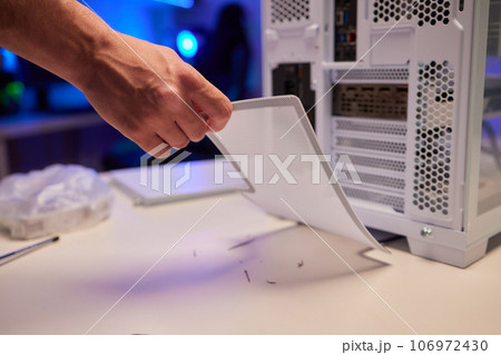 Close-up of technician's hand assembling personal computer. cleaning the dust bin 106972430