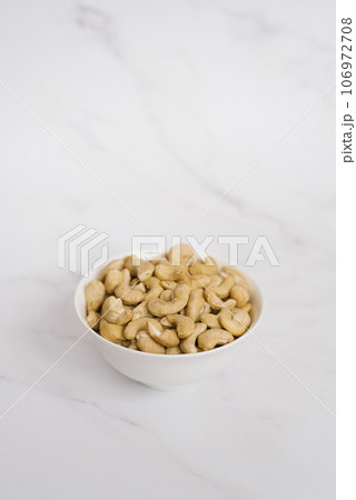 Cashew in a white bowl on a marble table Cashew in a white bowl on a marble table 106972708