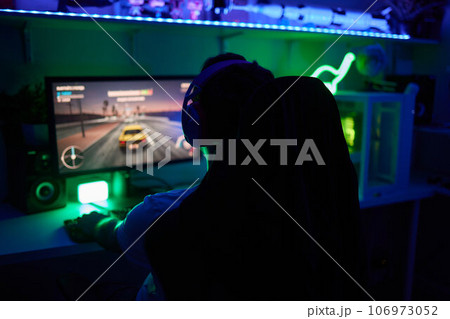 Player looking at his computer screen, contemplating his next move in an online video game. Player looking at his computer screen, contemplating his next move in an online video game. 106973052