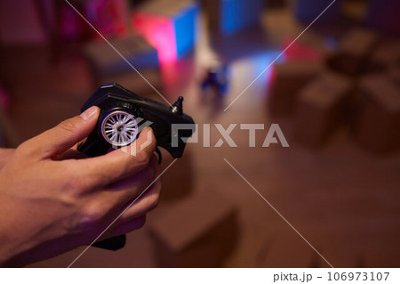 Young Caucasian male assembling toy RC car at home in the evening. Young Caucasian male assembling toy RC car at home in the evening. 106973107
