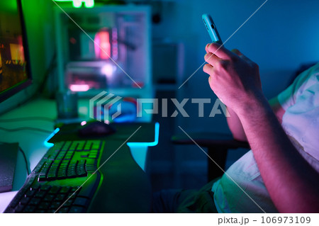 Player looking at his computer screen, contemplating his next move in an online video game. Player looking at his computer screen, contemplating his next move in an online video game. 106973109