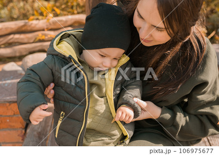Cute little asian boy stands outdoors. Happy child walking in autumn park. Toddler baby boy wears trendy jacket and hat. Autumn fashion. Stylish child outside. Cute little asian boy stands outdoors. Happy child walking in autumn park. Toddler baby boy wears trendy jacket and hat. Autumn fashion. Stylish child outside. 106975677