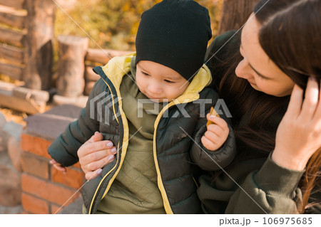 Cute little asian boy stands outdoors. Happy child walking in autumn park. Toddler baby boy wears trendy jacket and hat. Autumn fashion. Stylish child outside. Cute little asian boy stands outdoors. Happy child walking in autumn park. Toddler baby boy wears trendy jacket and hat. Autumn fashion. Stylish child outside. 106975685
