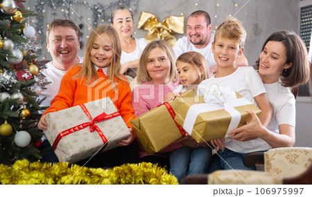 Family with children holding gifts in christmas interior Family with children holding gifts in christmas interior 106975997