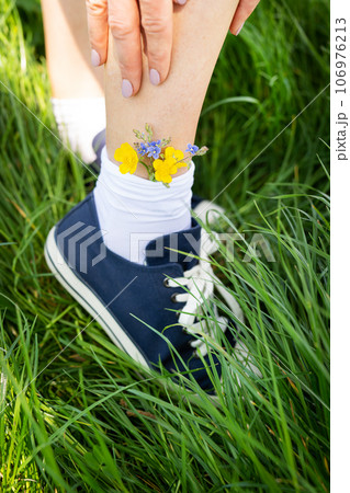 Bright flowers in blue sneakers, classic. Nice casual blue sneakers with white socks. Bright flowers in blue sneakers, classic. Nice casual blue sneakers with white socks. 106976213